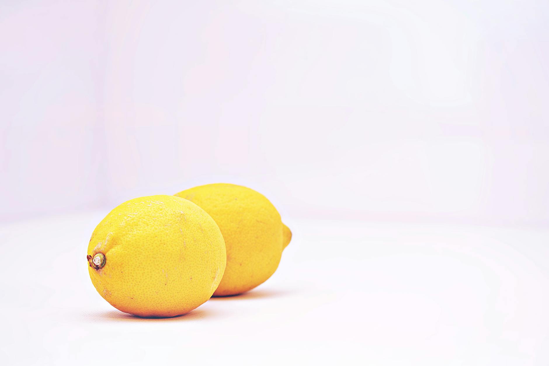 Two vibrant lemons on a minimalist white background, symbolizing fresh beginnings and renewal