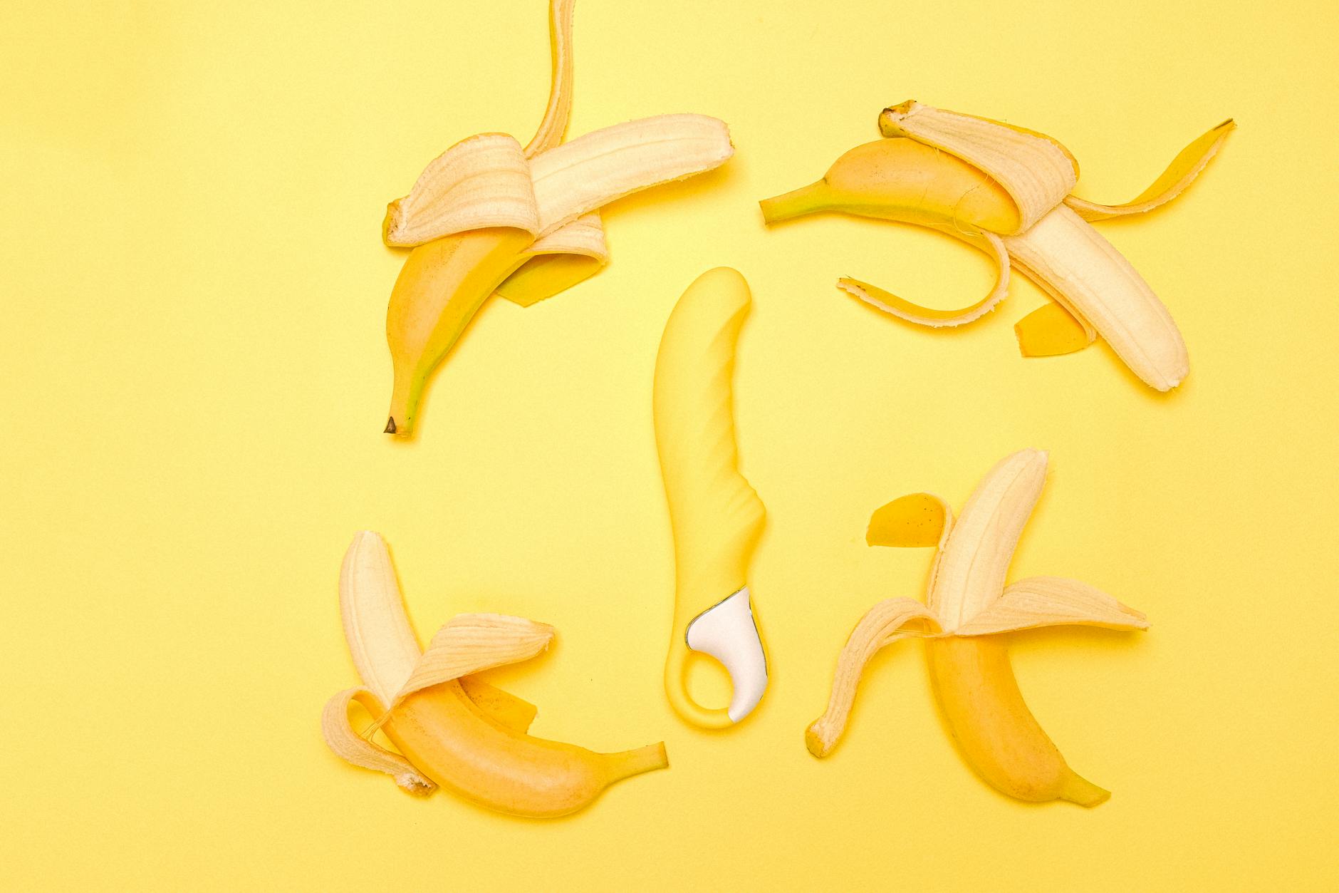 A yellow silicone lemon vibrator on a bright yellow background